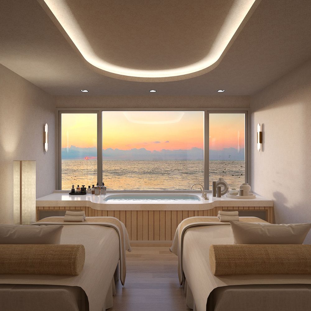 Beachfront wellness resort designed by Openbox Architects featuring a bright open lobby with ocean views, natural light through glass roof, and warm coastal materials.