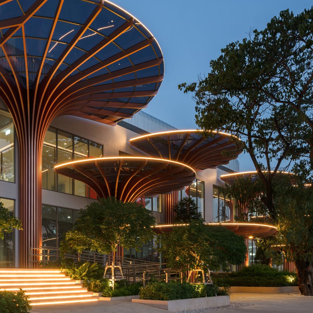 NAP+ Factory entrance by OPNBX showcasing modern biophilic architecture and glowing tree-shaped canopy columns.